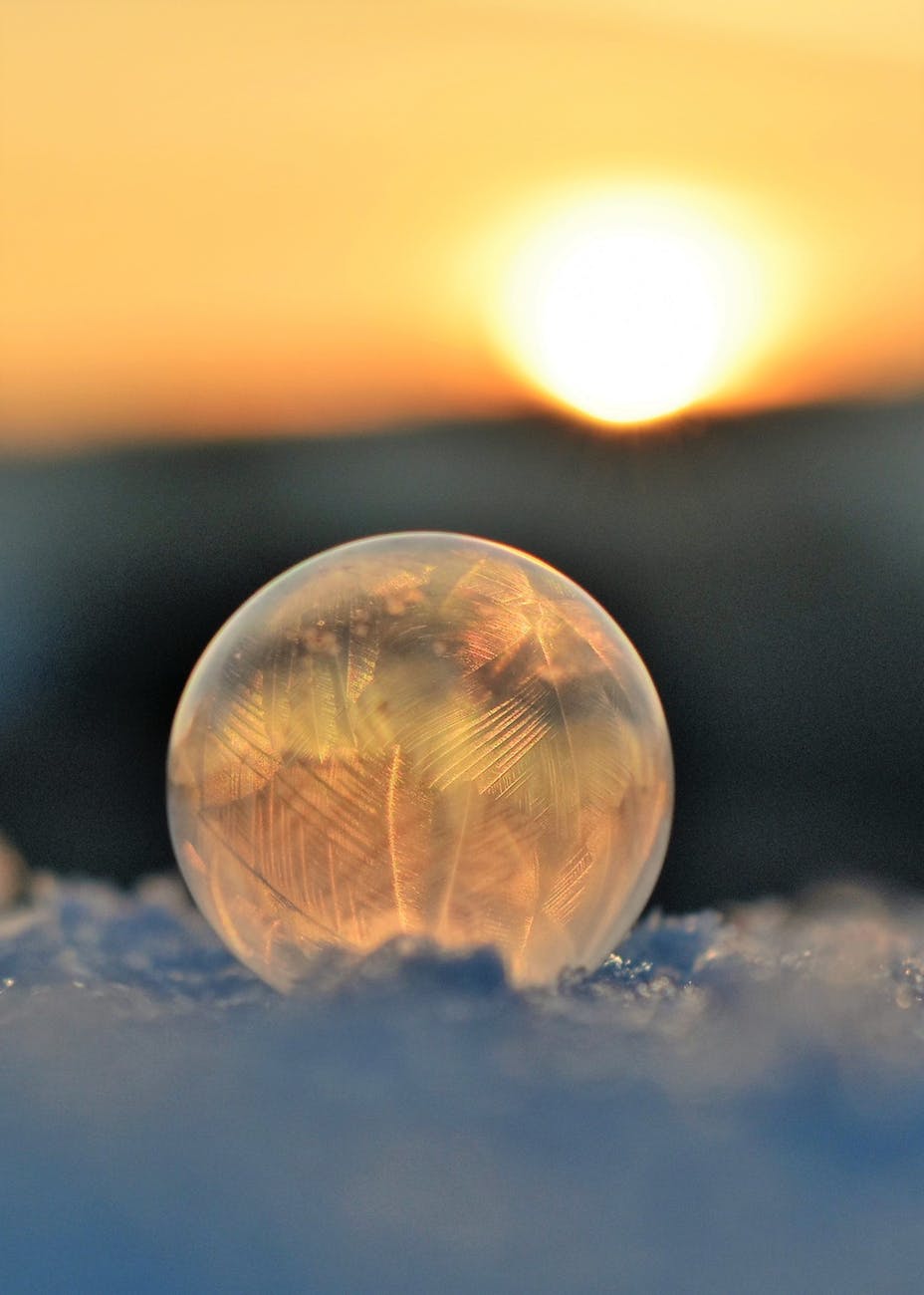 frozen soap bubble against sky during sunset